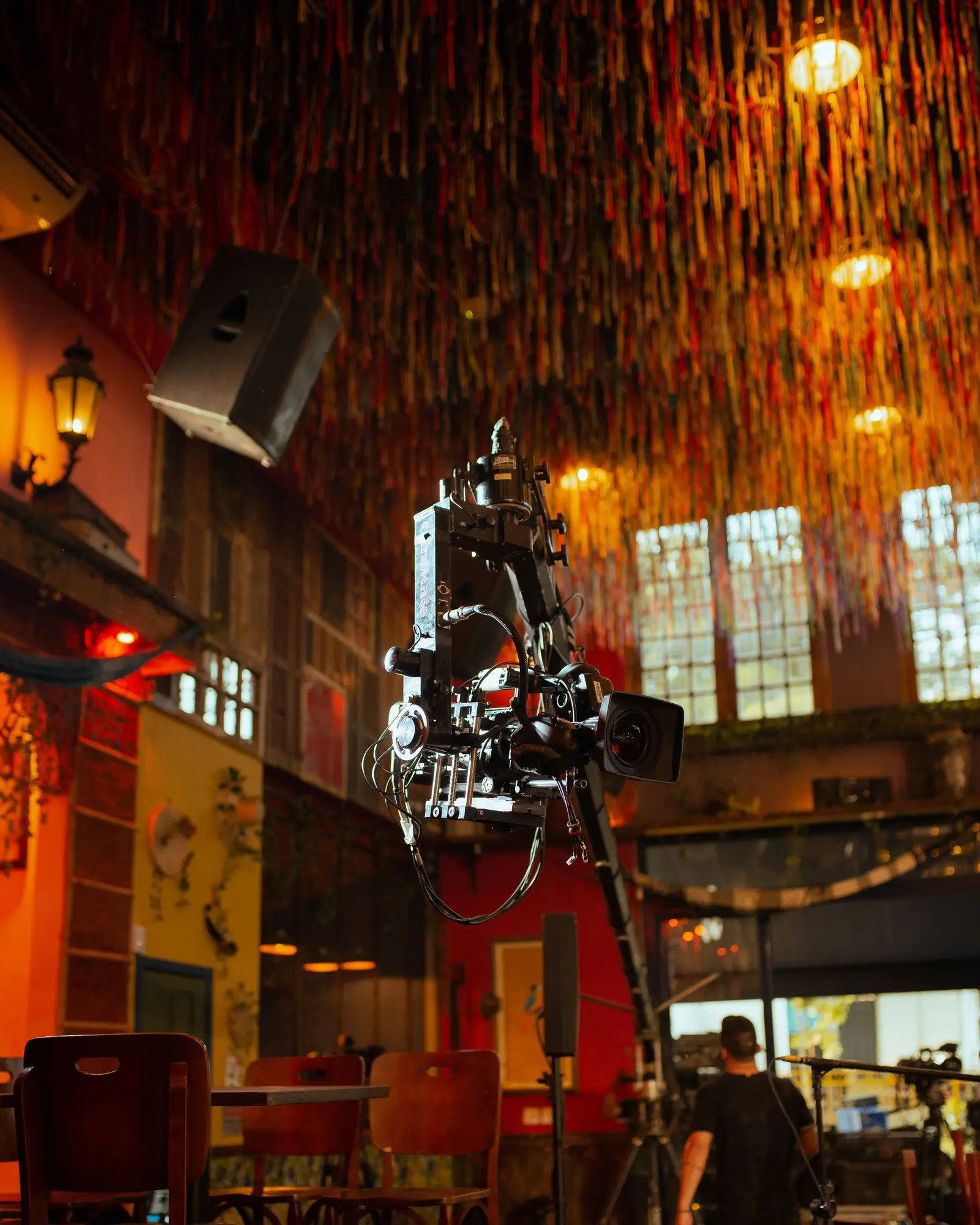 Camera mounted on a jib arm above an event floor.