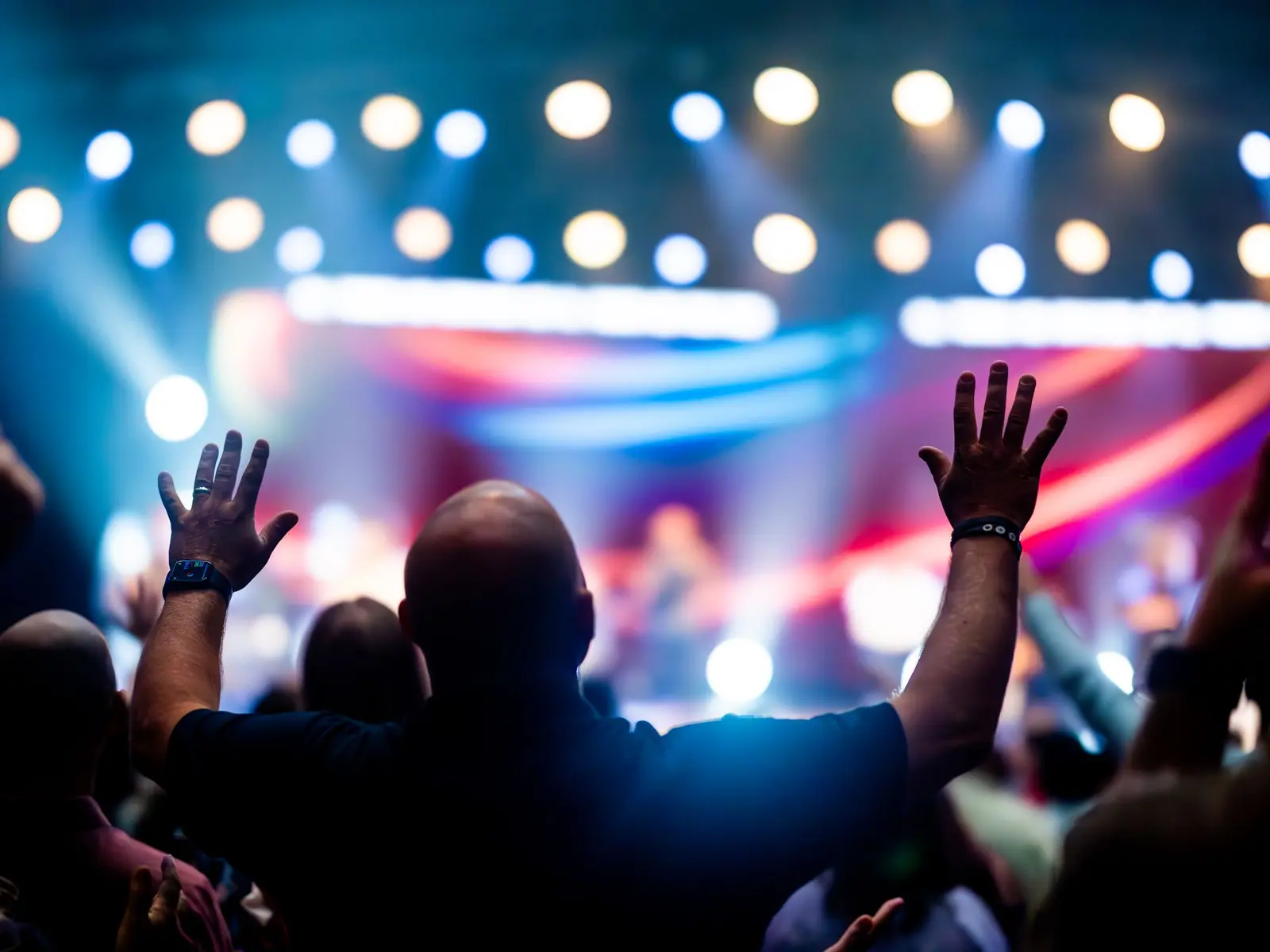 Audience with raised hands during a live performance.