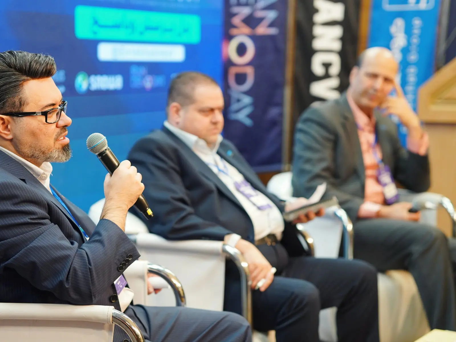 Panel discussion on stage at a corporate conference with the audience in the foreground.