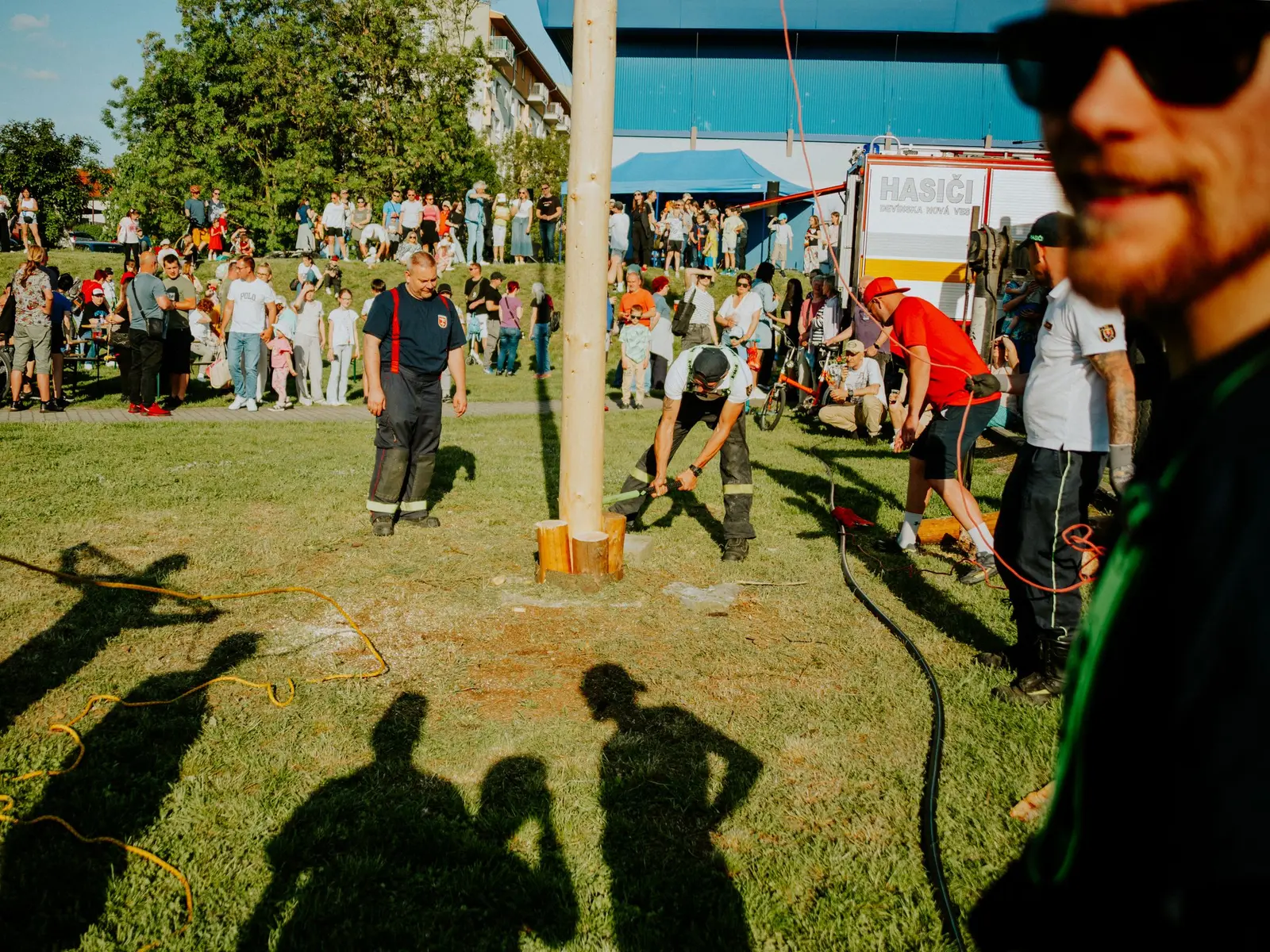 Outdoor community festival with stalls, seating and visitors moving between activities.