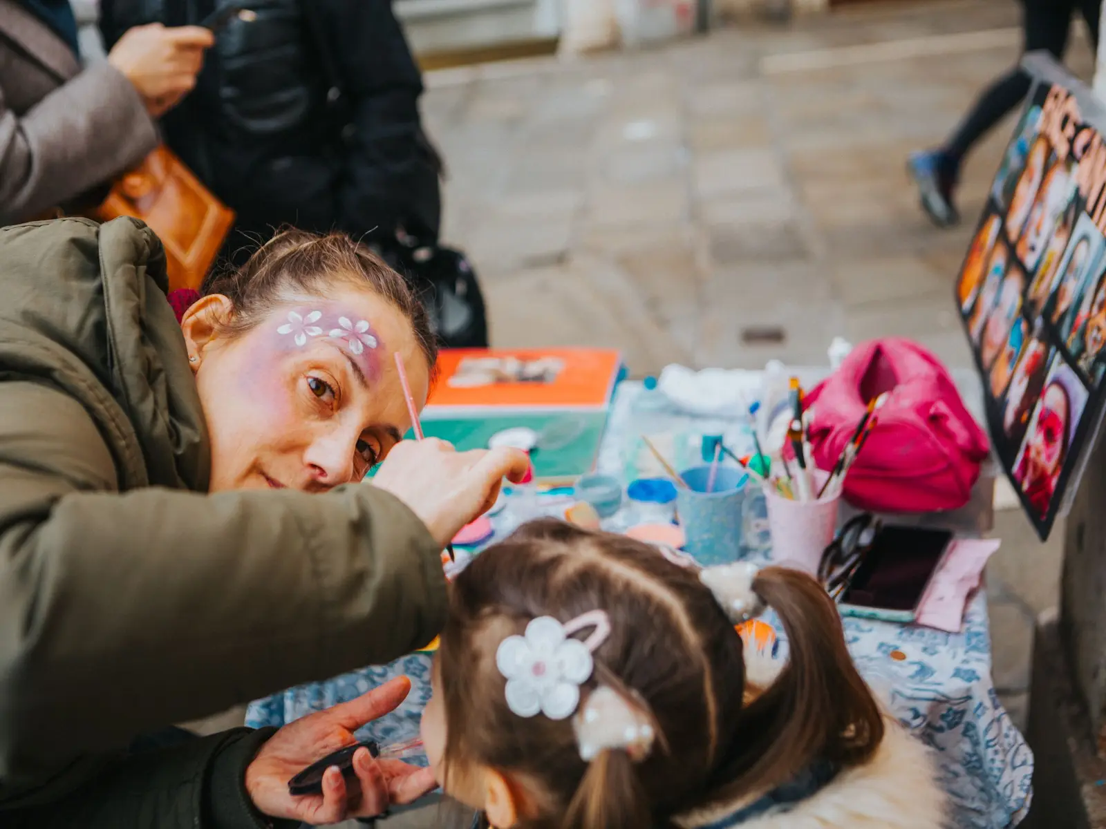 Face-painting activity for children at a street arts festival.