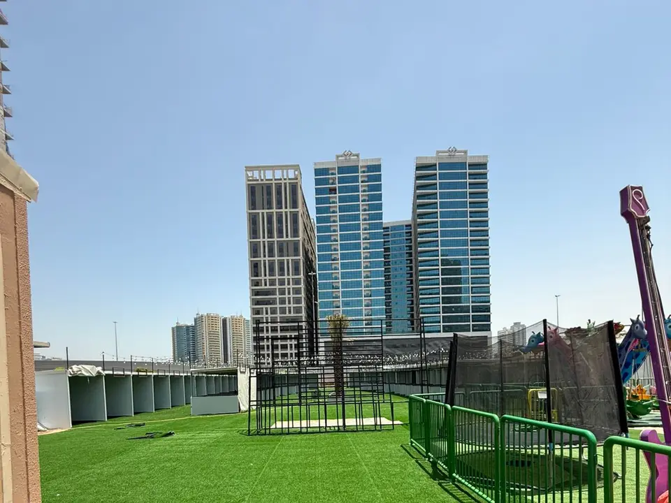 Outdoor exhibition structures and visitor areas prepared beside a city venue.