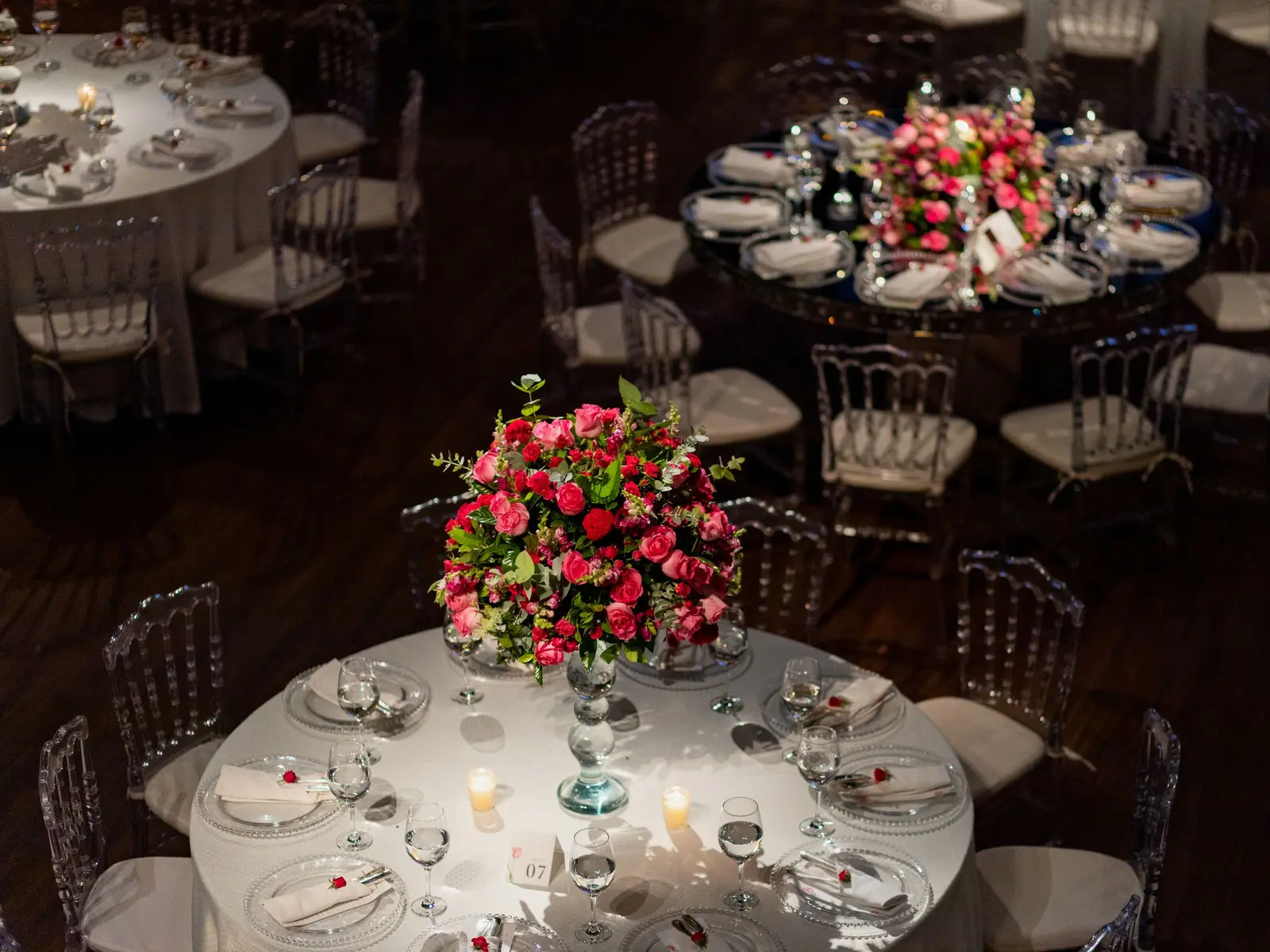Wedding reception hall with round tables set before guests arrive.