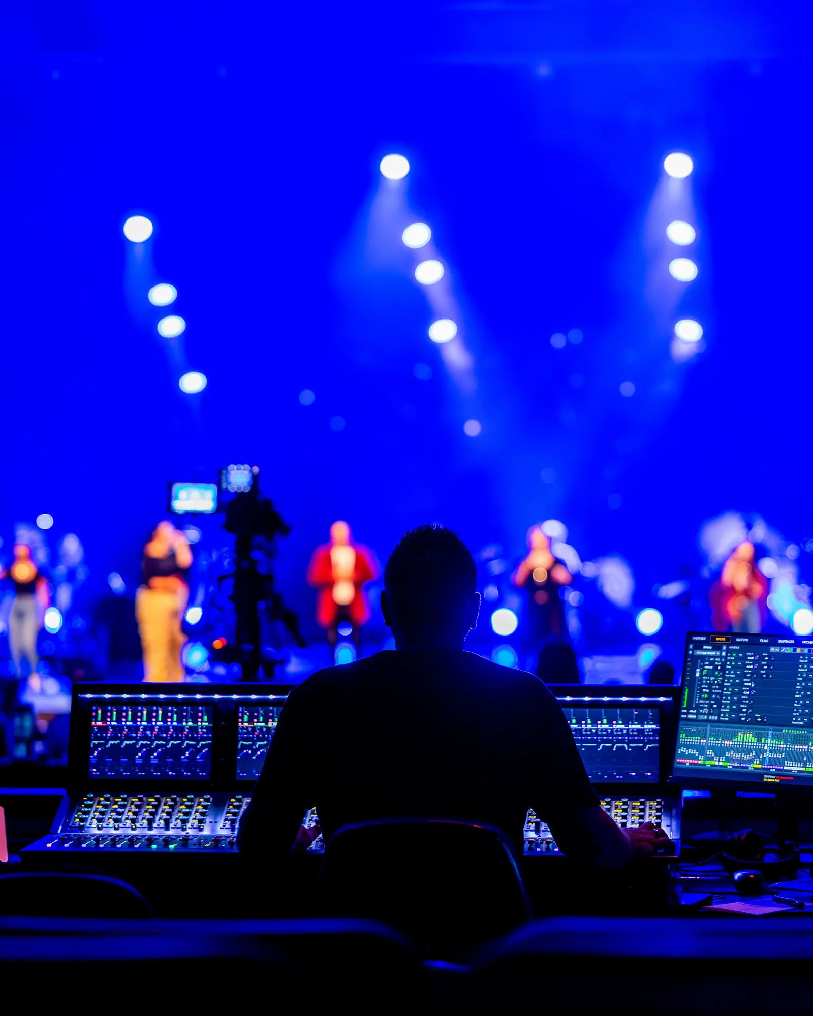 Sound engineer working a mixing desk during a live show.