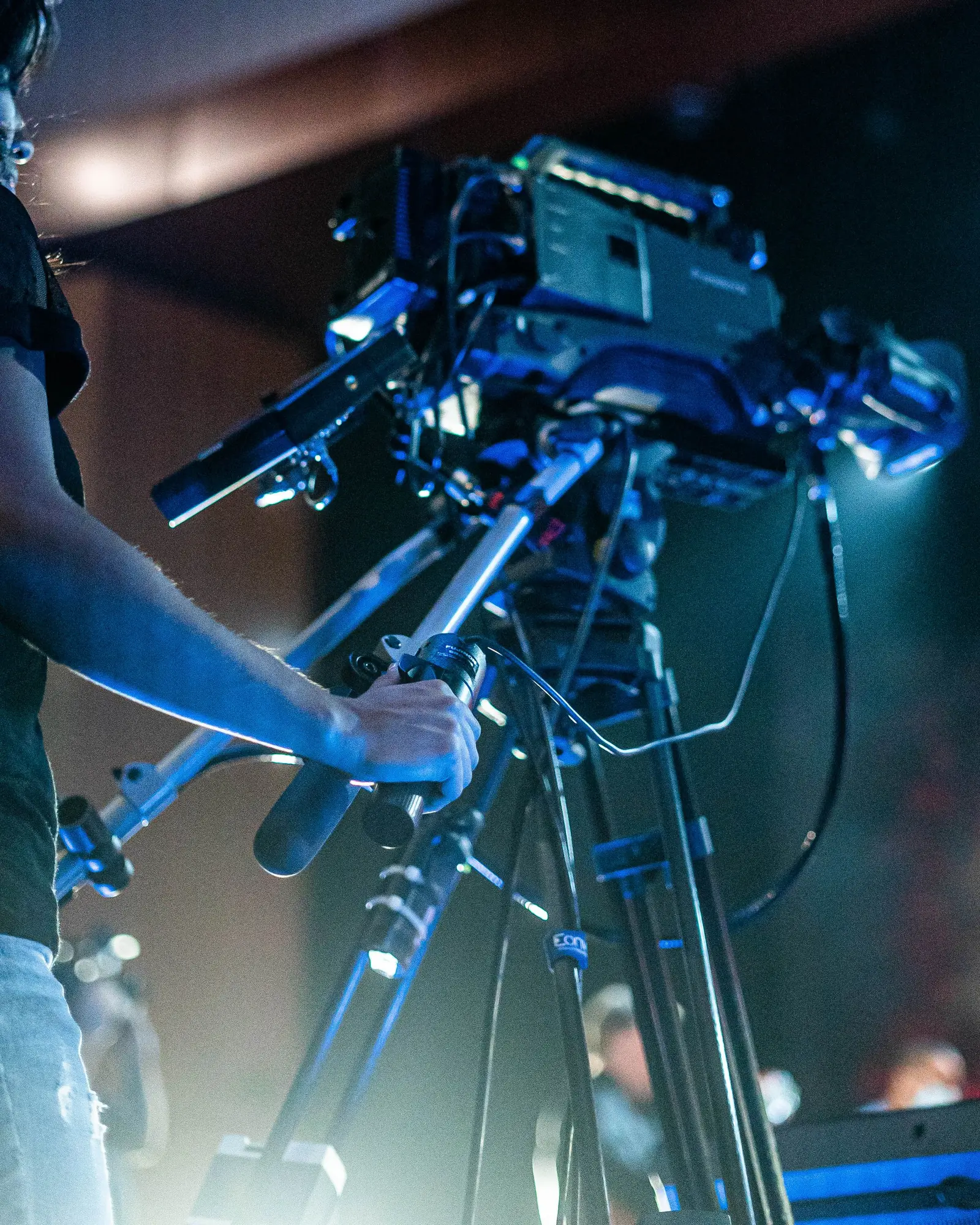 Videographer filming a music event from the side of the stage.